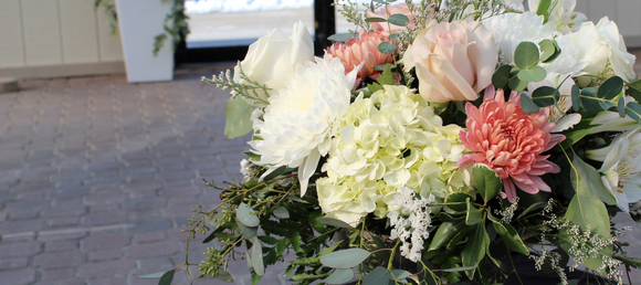 Wedding bouquet of white and pink flowers arranged in a sleek black vase, showcasing a romantic and elegant floral design.