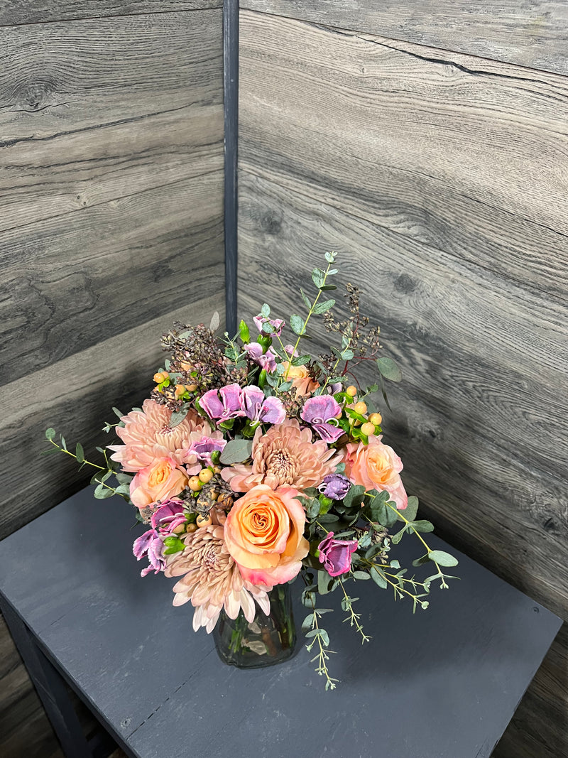 A variety of wedding floral arrangements, including lush centerpieces, elegant arch decor, free-standing ground installations, and delicate table accents. Featuring roses, peonies, wildflowers, and greenery, complemented by candles and soft lighting for a romantic ambiance.