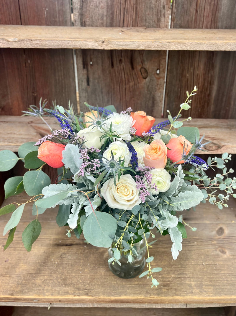 A variety of wedding floral arrangements, including lush centerpieces, elegant arch decor, free-standing ground installations, and delicate table accents. Featuring roses, peonies, wildflowers, and greenery, complemented by candles and soft lighting for a romantic ambiance.